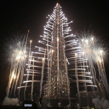Crowds look at fireworks bursting around