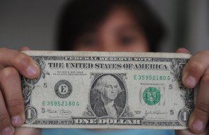 A person holds a one dollar bill on Dece