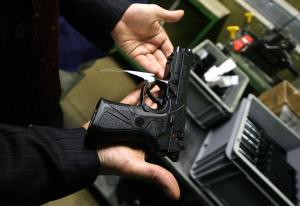 A technician holds a Beretta 92S semi-au