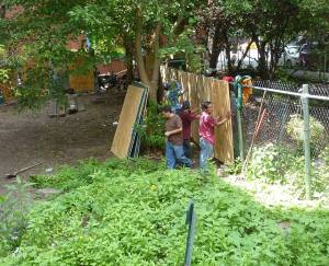 Construction crew from developer Serge Hoyda putting up plywood across a fence, separating their lot from the Children's Magic Garden. (Photo by Aresh Javadi).