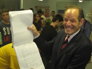 Eliot Spitzer gleefully displays a page of his petition signatures.