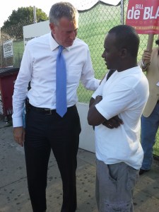 Bill de Blasio talks to a voter outside of the Utica Avenue subway stop.