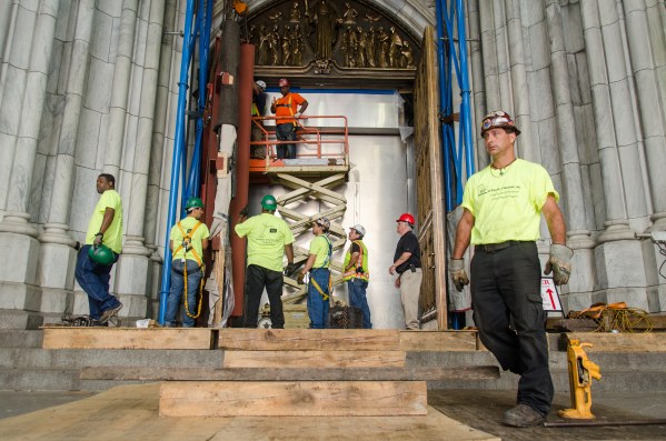 A team of workers supervised the re-installation of the doors. (Fernando Gomes)