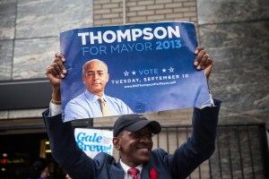 A man holds up a Thompson poster on Election Day. (Photo: Getty)