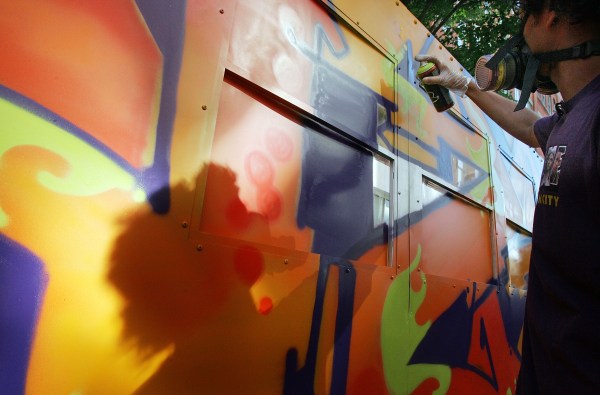 Graffiti artist Daze paints a mock subway car at Mark Ecko's "Getting Up" block party in 2005. (Photo by Mario Tama/Getty Images)