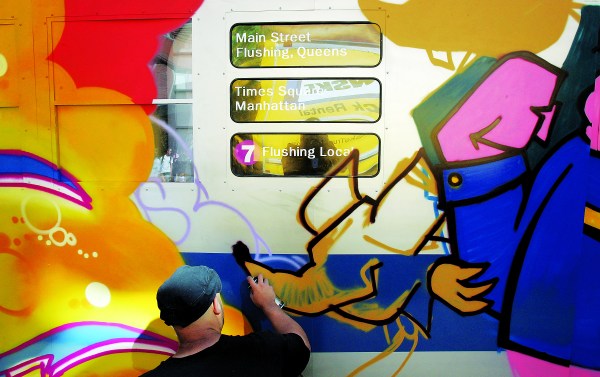 A graffiti artist spraypaints a mock subway car at Mark Ecko's "Getting Up" block party in 2005. (Photo by Mario Tama/Getty Images)