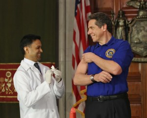 Andrew Cuomo shows off one of his guns while getting a flu shot. (Photo: Flickr/governor's office.)