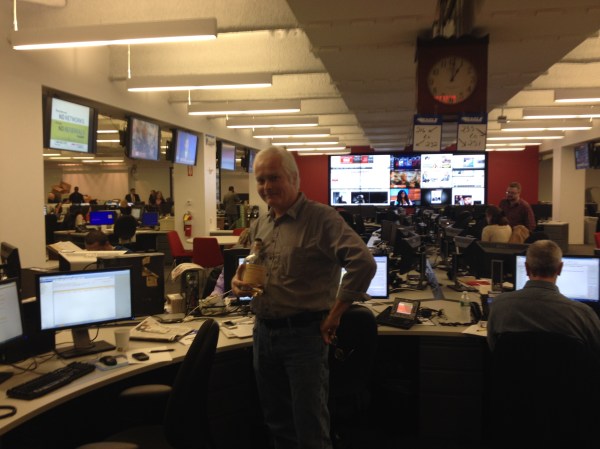 Mr. Siemaszko poses with one of the bottles of scotch that sustained him and his fellow staffers during the night they were trapped in the newsroom.