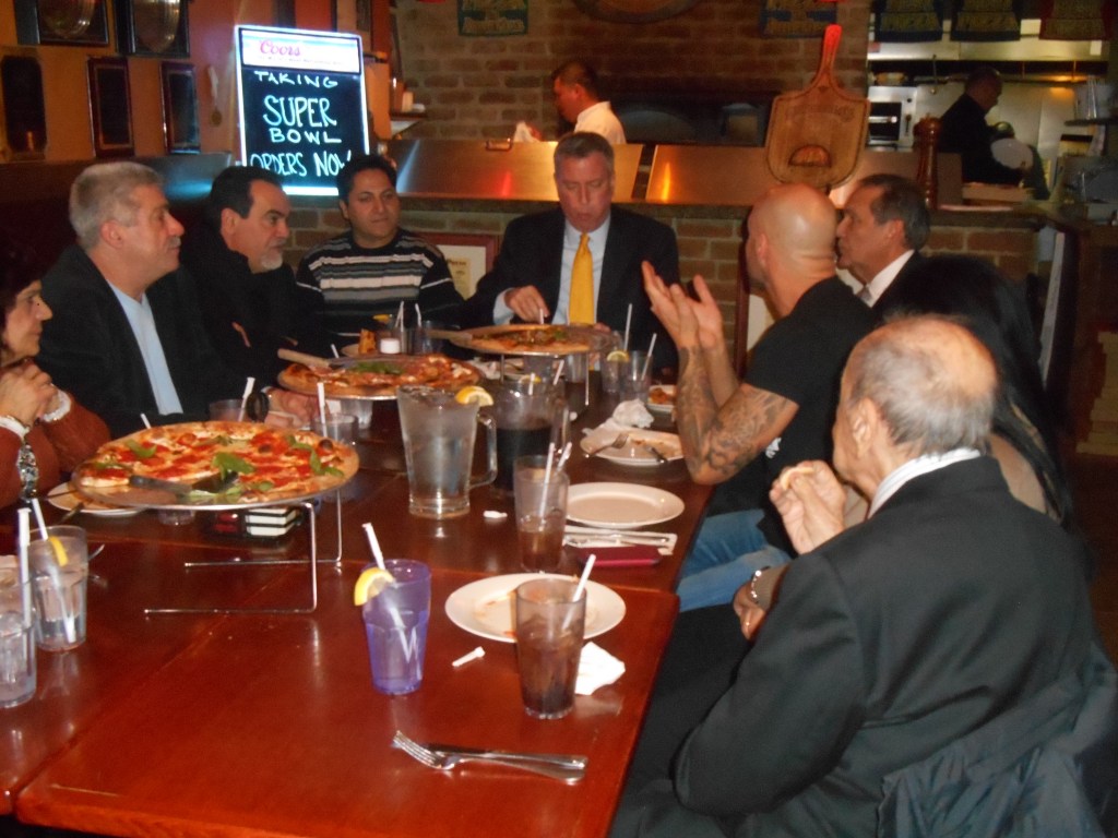 Mayor Bill de Blasio eats pizza with a fork.