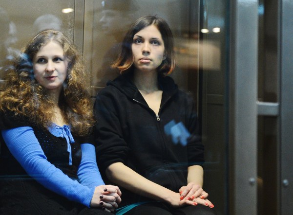 Maria Alyokhina and Nadezhda Tolokonnikova, sitting in a glass-walled cage in a court in Moscow. (Photo by NATALIA KOLESNIKOVA/AFP/GettyImages)
