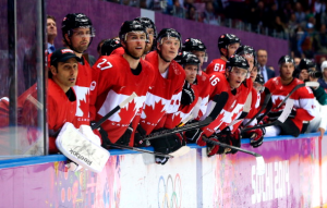 Team Canada players watching the Canada-U.S. semifinal game. (Getty)