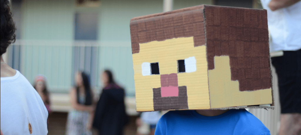 A Minecraft enthusiast above wears a headpiece depicting the Minecraft avatar, which is the only total immersion experience available for the foreseeable future.  (photo: Andrew Beeston, CC BY 2.0)