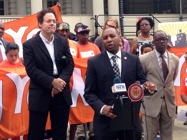 Council members and activists call for eminent domain on the steps of City Hall.