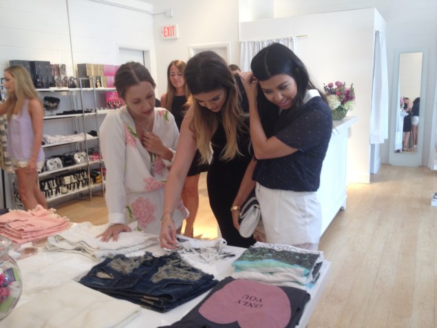 Khloé and Kourtney check out the merchandise (and Jordyn snaps some iPhone photos before a crew member tells her to cut it out). (Photo: Jordyn Taylor)