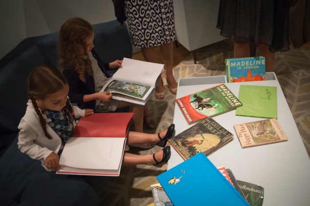 Two girls reading Madeline books on the couch in the exhibit. (Kaitlyn Flannagan)