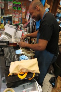 Mr. Powell smiles at he works at the counter in his shop. (Courtesy of Duane Harper Grant)
