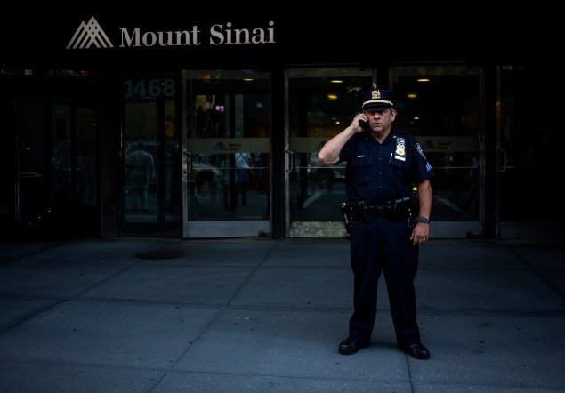 An officer outside Mount Sinai Hospital, where a patient was tested for the Ebola virus. (Photo by Eric Thayer/Getty Images)