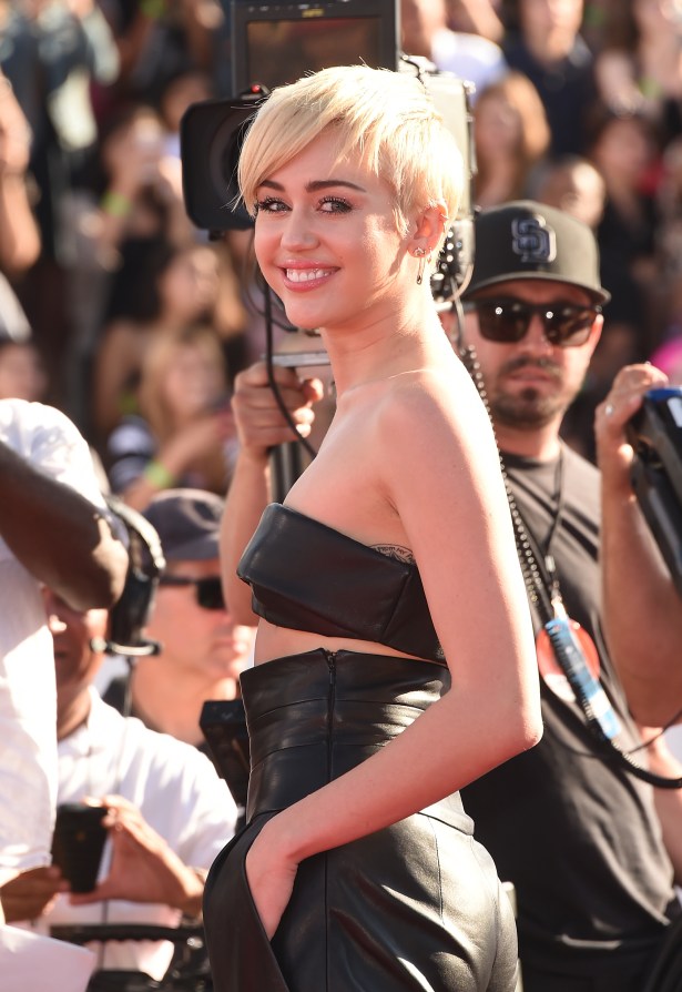 Miley reaching for her iPhone (jk) at the VMAs. (Photo via Getty)