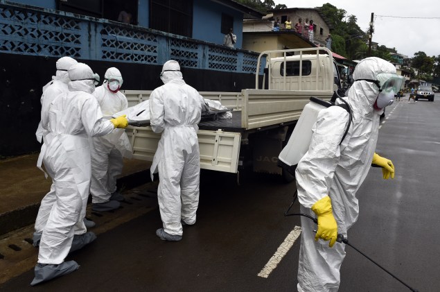 Liberian health workers handle the body of an Ebola victim (cPhoto: Pascal Guyot/AFP/Getty Images).
