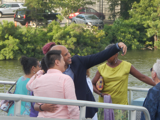 Senator Cory Booker snaps a picture with supporters on his way onto the Battleship New Jersey in Camden's harbor