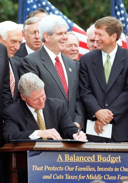 WASHINGTON, : US House Majority Leader Newt Gingrich (2nd-R), R-GA, talks with John Kasich (R), R-OH, while US President Bill Clinton signs the Balanced Budget Agreement on the South Lawn of the White House 05 August in Washington. The budget agreement, which will balance the federal budget by the year 2002, includes the largest tax cuts in 16 years as well as an increase in tobacco tax. AFP PHOTO Paul J. RICHARDS (Photo credit should read PAUL J. RICHARDS/AFP/Getty Images)