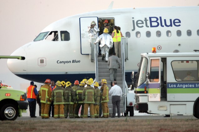 Emergency workers board JetBlue flight 292 as it sits on the runway after making an emergency landing. (Photo by Jeff Gross/Getty Images)