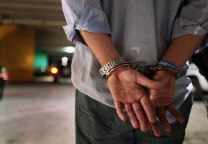  A driver who failed a field sobriety test at a DUI traffic checkpoint stands in handcuffs waiting to be processed June 4, 2007 in Miami, Florida. Several law enforcement agencies were conducting the checkpoint and conducting saturation patrols to help save lives during the 4th of July holiday. The National Safety Council has rated the July 4th holdiay as one of most lethal holidays for drivers, with alcohol factoring into nearly half of all motor vehicle deaths. (Photo by Joe Raedle/Getty Images)