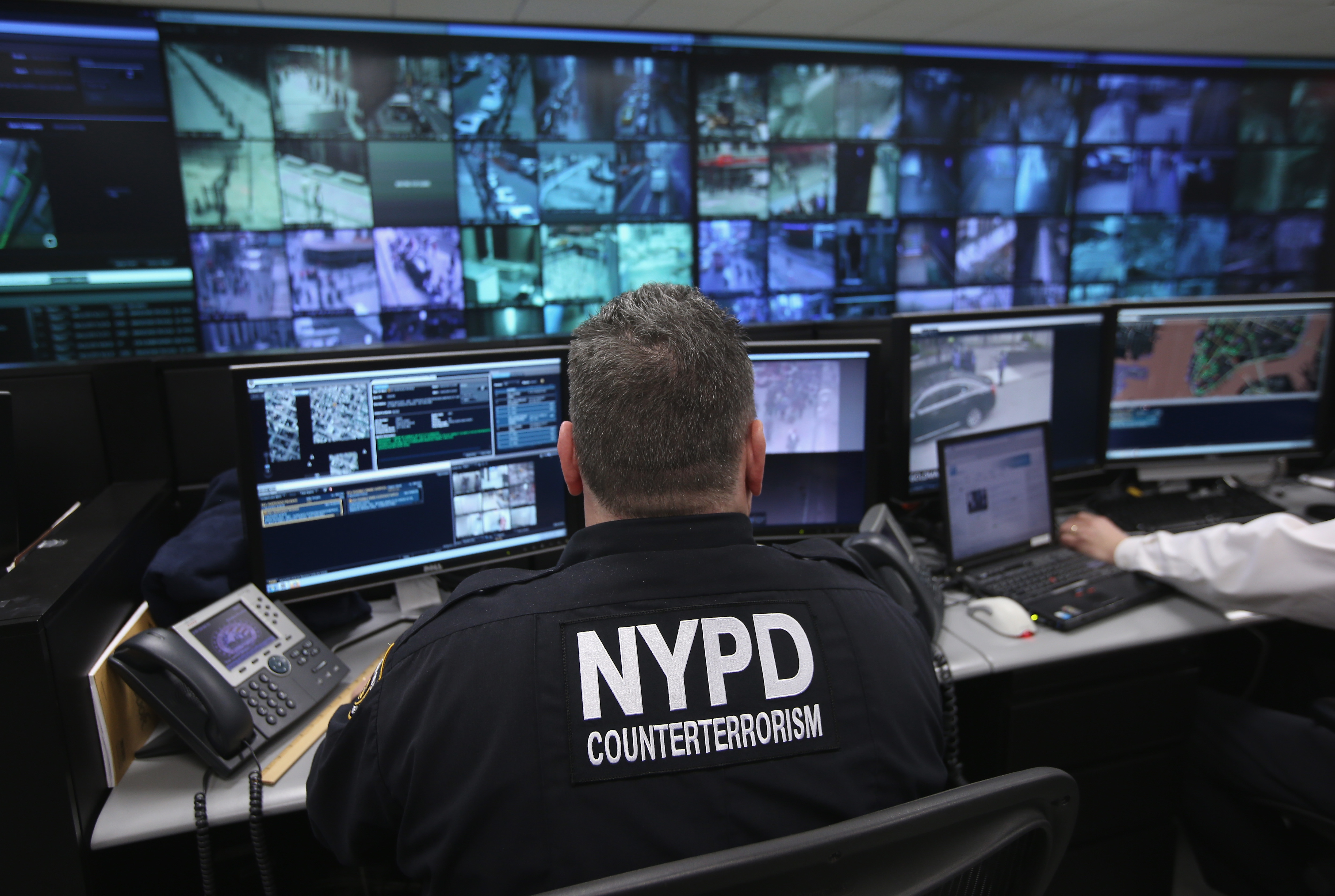 An NYPD officer watches security camera footage.