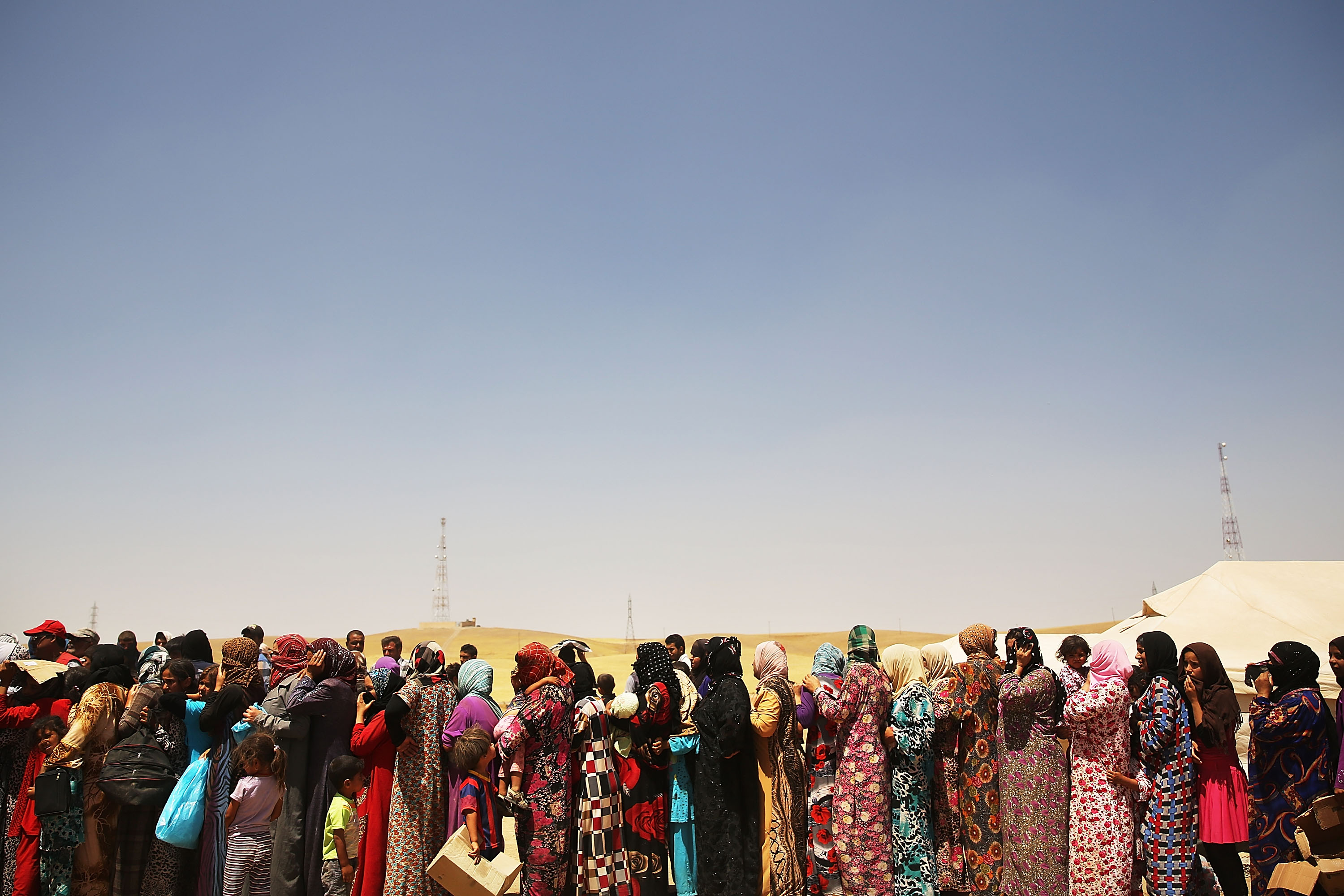 Iraqi women displaced from Mosul by extremist fighters stand on a food line in Khazair, Iraq. (Photo: Spencer Platt/Getty Images)