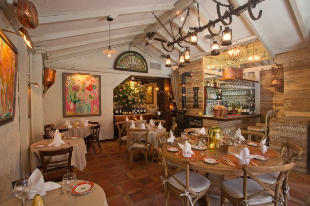 The restaurant’s interior is a Provençal fantasia of copper pans, poppy paintings and arcane farm equipment. (Photo courtesy Shorine)