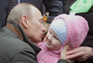 Russian  Prime Minister Vladimir Putin kisses a baby during a visit near St. Petersburg. (ALEXEY DRUZHININ/AFP/Getty Images)