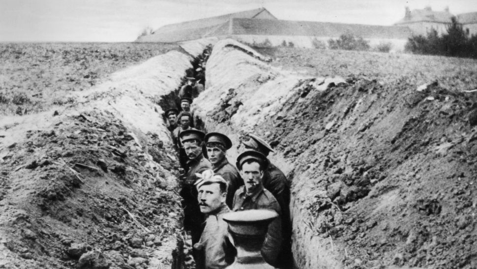 During the first Christmas of World War One, combatants on both sides temporarily put down their arms for a night of signing and eating and possibly even soccer. This photo, taken October 28, 1914, shows British soldiers lined up in a narrow trench. (Photo by Hulton Archive/Getty Images)