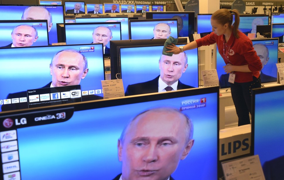 An employee wipes a TV screen in a shop in Moscow during a broadcast of President Vladimir Putin. (ALEXANDER NEMENOV/AFP/Getty Images)