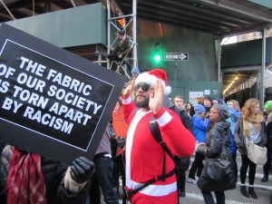 A SantaCon participant symbolically throws his hands up (Photo: Will Bredderman).