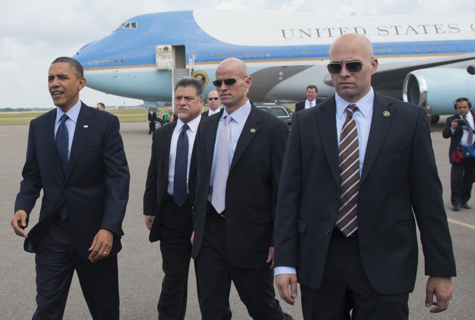 US President Barack Obama (L), surrounded by US Secret Service agents, walks to greet guests upon arrival on Air Force One at Tampa International Airport in Tampa, Florida, on April 13, 2012. (SAUL LOEB/AFP/Getty Images)
