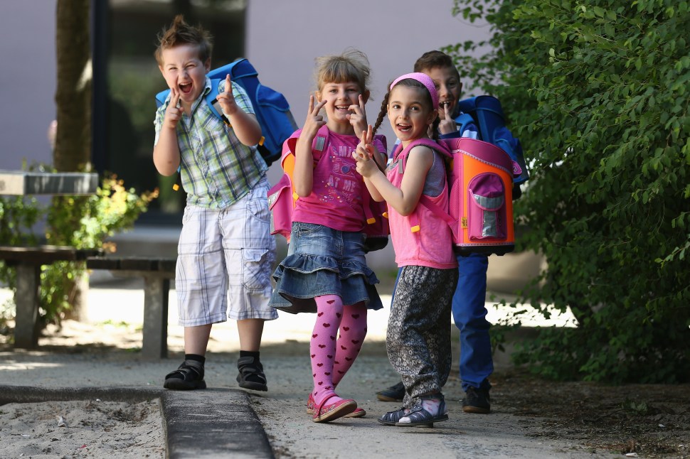 (L-R) The kids Dario, Natalie, Eleni and Ferhart from kindergarten 'Schneckenhaus' walk along a path with their new satchels on June 5, 2013 in Berlin, Germany. (Photo by Andreas Rentz/Getty Images)