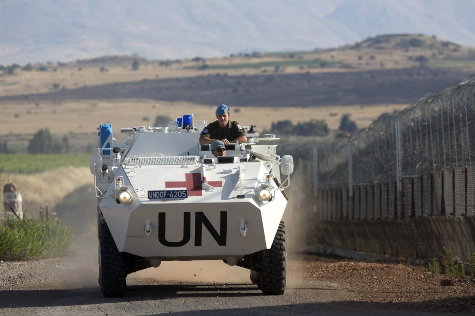 A United Nations (UN) peacekeeper vehicle make its way along the Israeli border with Syria next to the crossing of Quneitra between Syria to the Israeli annexed Golan Heights on June 12, 2013. (Photo: Menahem Kahana/Getty Images)