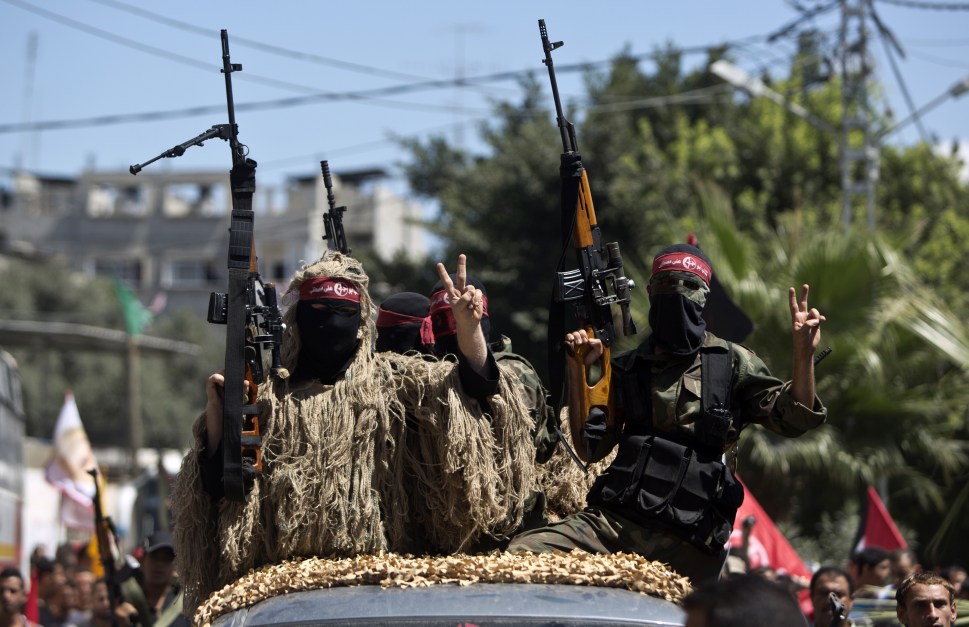 Masked Palestinian militants of the Popular Front for the Liberation of Palestine (PFLP), hold-up their rifle flashing the sign of victory on September 2, 2014 in Gaza city during a rally to celebrate a week after the Egypt-mediated ceasefire between Israel and Hamas. Israel announced on September 1, 2014 it will expropriate 400 hectares (988 acres) of Palestinian land in the occupied West Bank, angering the Palestinians and alarming Israeli peace campaigners. AFP PHOTO/MAHMUD HAMS (Photo credit should read MAHMUD HAMS/AFP/Getty Images)