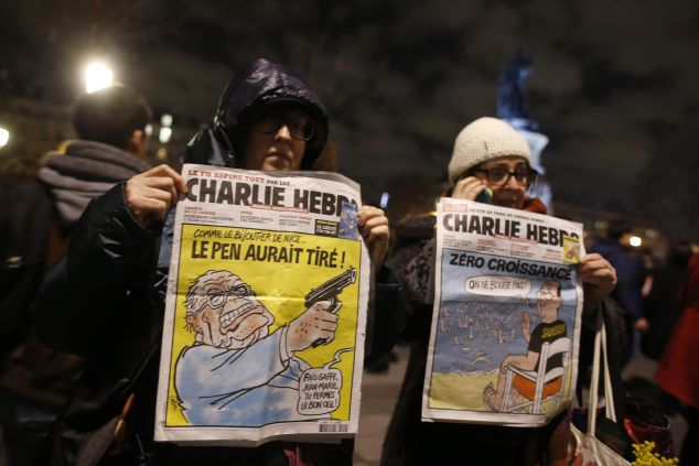 Women in Paris hold Charlie Hedbo's front pages as a tribute to the slain journalists.