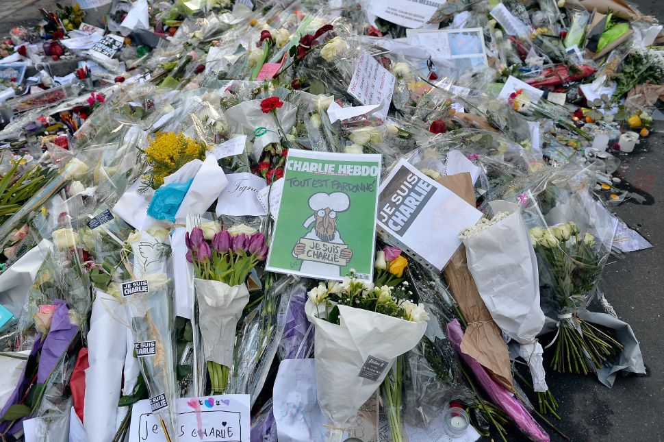 PARIS, FRANCE- Tributes of drawings, flowers, pens and candles are left in front of the Charlie Hebdo offices on January 14, 2015 in Paris, France. 