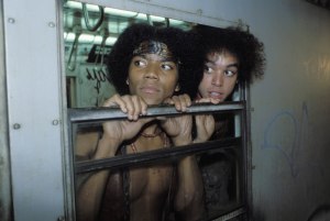 Two of the Warriors peek from inside a graffiti-covered subway. (Photo via thewarriors.co.uk)