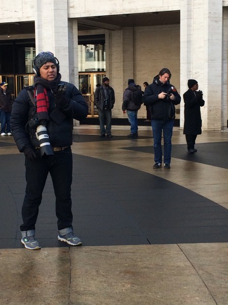 Photographers stand around the plaza, waiting for the perfect photo-worthy look to emerge from the tents