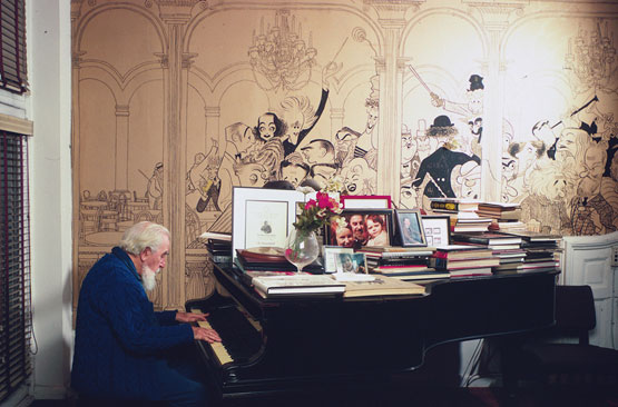 Al Hirschfeld photographed by Jill Krementz on December 4th, 1971, playing the piano in his living room. The house, with mural intact, was sold by his widow after she married Mr. Cullman and moved to Park Avenue. (Photo: © Jill Krementz)