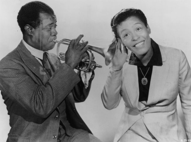 Billie Holiday pays close attention to Louis Armstrong. (Photo: Hulton Archive/Getty Images)