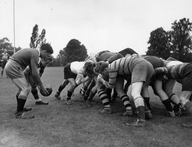 A rugby team gets in a scrum.