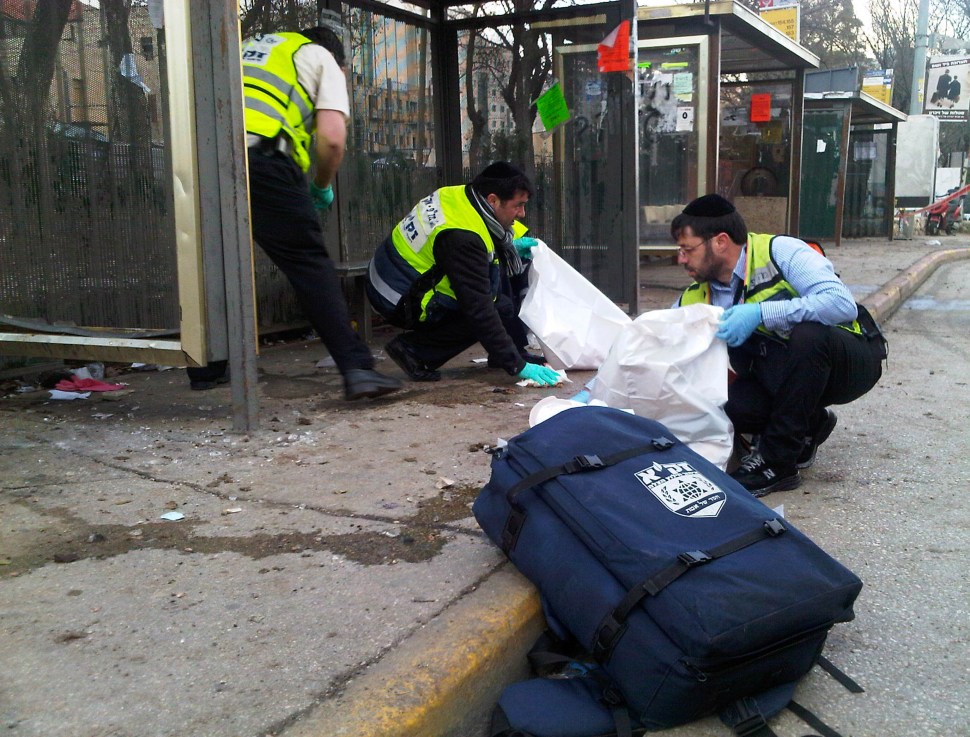 Ultra Orthodox ZAKA volunteers clean up at the scene after an explosion near a bus stop March 23, 2011 in central Jerusalem, Israel. (Photo: ZAKA via Getty Images)