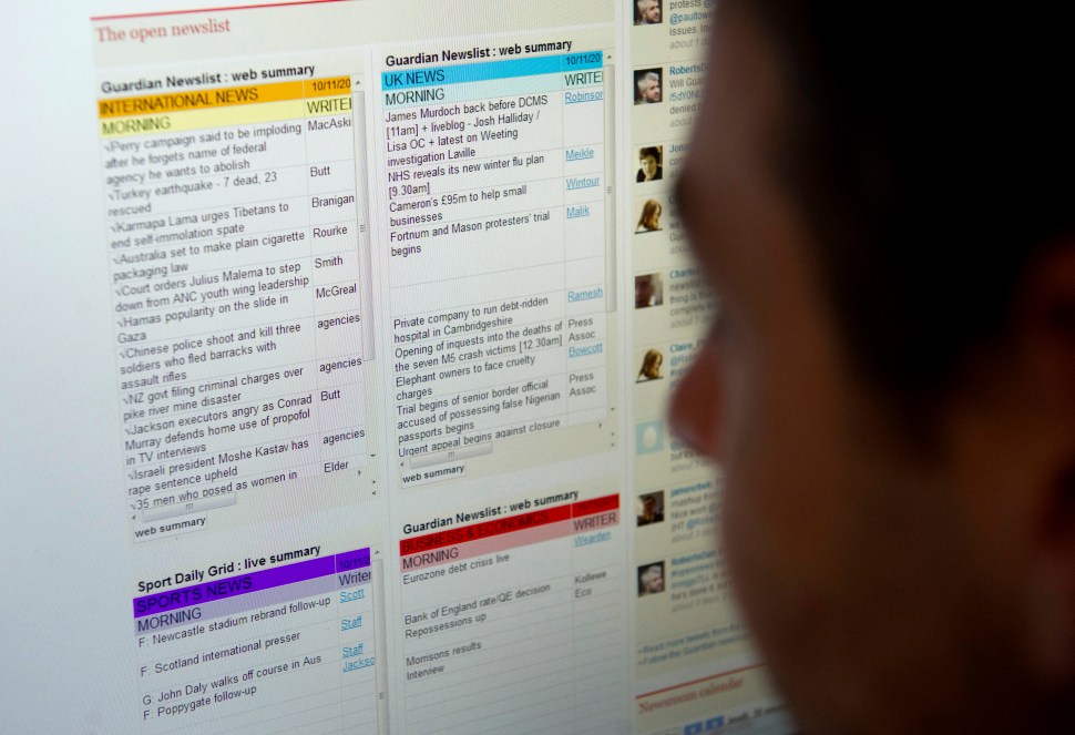 TO GO WITH STORY BY KATY LEE A journalist poses looking at a computer screen showing the Guardian's "newslist" on the British newspaper's website in an office in London on November 10, 2011. The Guardian newspaper has opened the way for its readers to look over the shoulders of its reporters, at least virtually. The newspaper decided to publish on its website a "newslist", listing the items on which its journalists are working and invites readers to support comment on their choice of material through Twitter.  AFP PHOTO / CARL COURT (Photo credit should read CARL COURT/AFP/Getty Images)