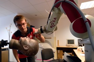 An engineer checks a robot used by neurosurgeons. BORIS HORVAT/AFP/Getty Images)