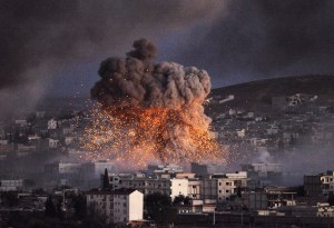 An explosion rocks Syrian city of Kobani during a reported suicide car bomb attack by the militants of Islamic State (ISIS) group on a People's Protection Unit (YPG) position in the city center of Kobani, as seen from the outskirts of Suruc, on the Turkey-Syria border, October 20, 2014. (Photo: Gokhan Sahin/Getty Images)