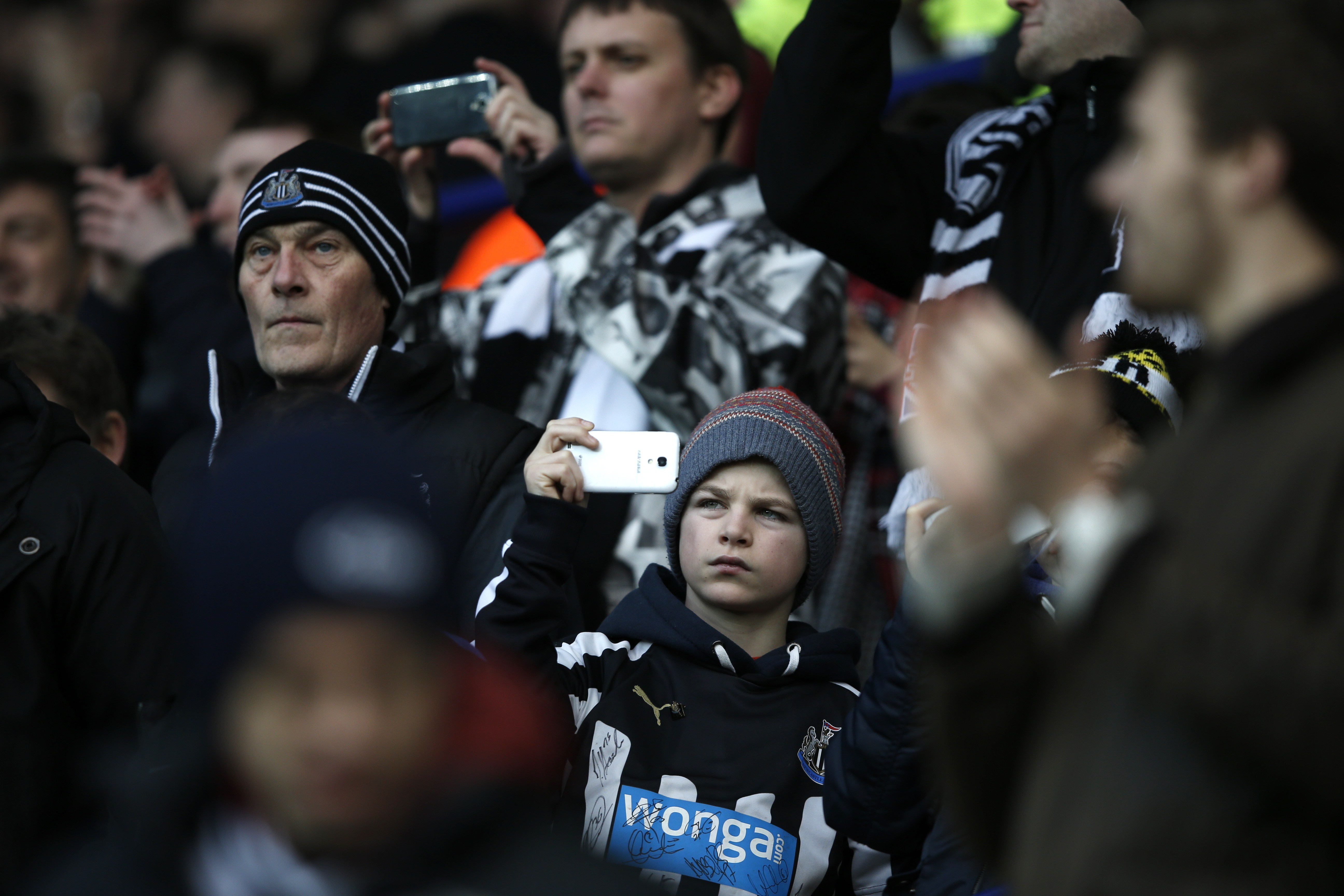 A Newcastle fan uses his mobile phone before kick off of the English FA Cup third round football match between Leicester City and Newcastle United at King Power Stadium in Leicester, central England on January 3, 2015. AFP PHOTO / ADRIAN DENNIS RESTRICTED TO EDITORIAL USE. No use with unauthorized audio, video, data, fixture lists, club/league logos or live services. Online in-match use limited to 45 images, no video emulation. No use in betting, games or single club/league/player publications.        (Photo credit should read ADRIAN DENNIS/AFP/Getty Images)